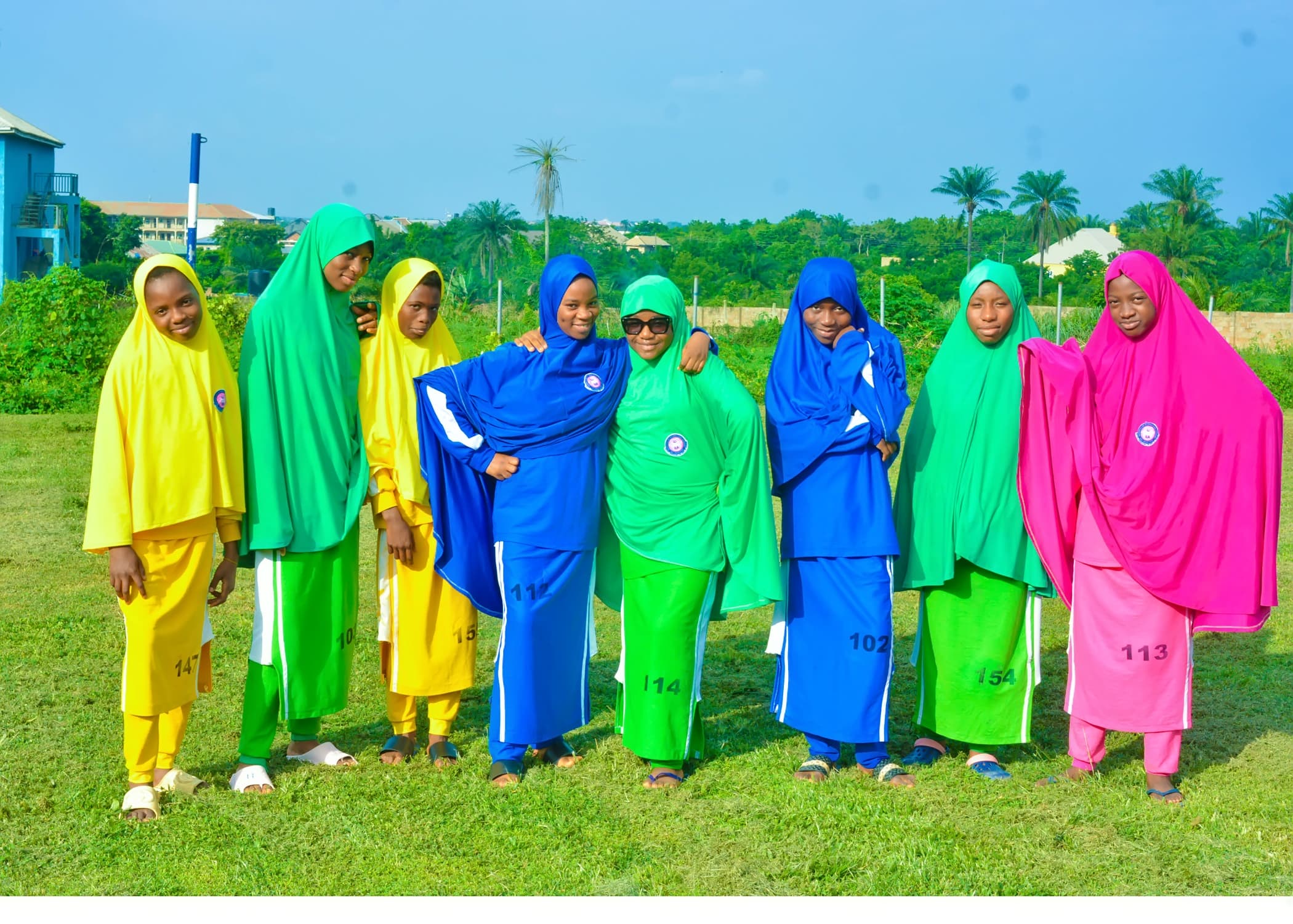 Inaayatullah students standing together in their sports house uniforms