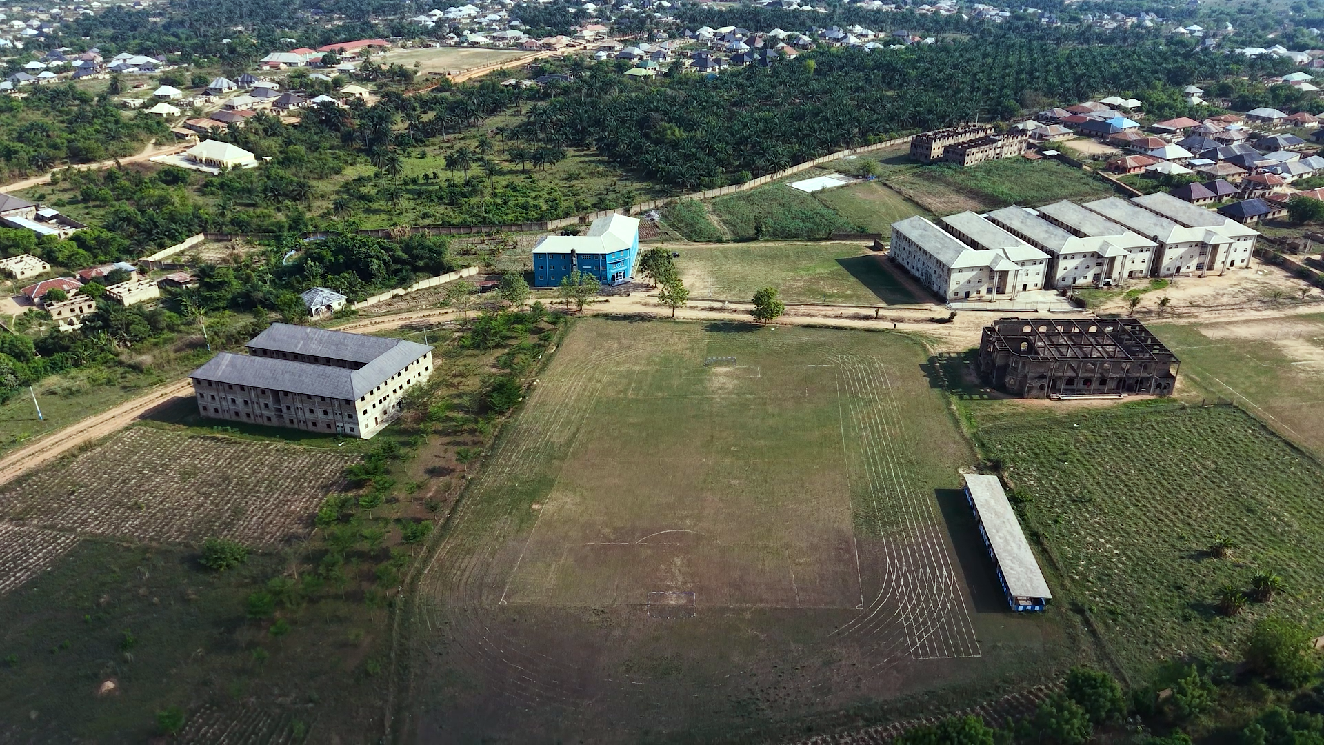 An aerial view of the Inaayatullah campus, sports field and surrounding community