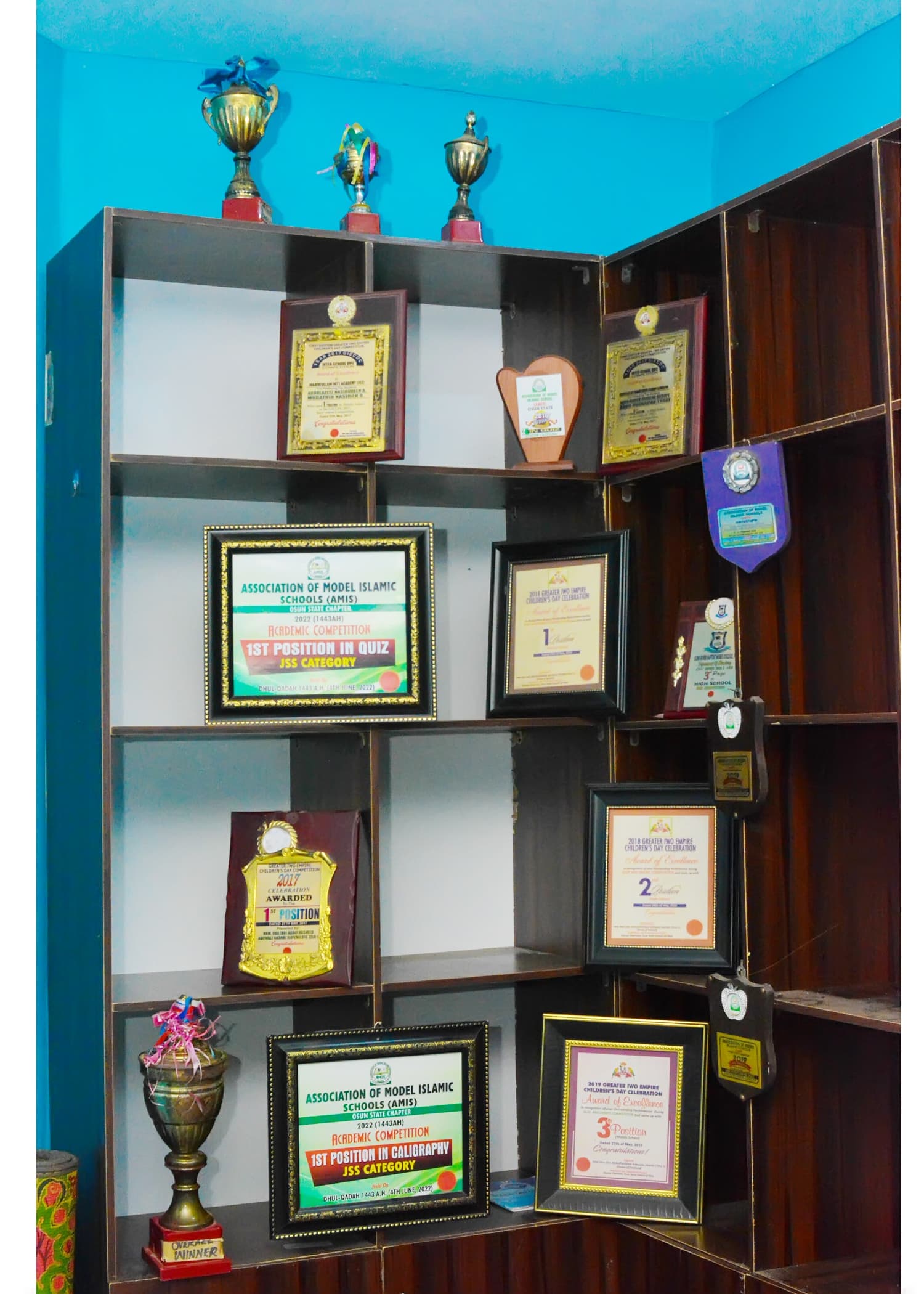 Trophies and framed competition awards displayed at Inaayatullah Academy