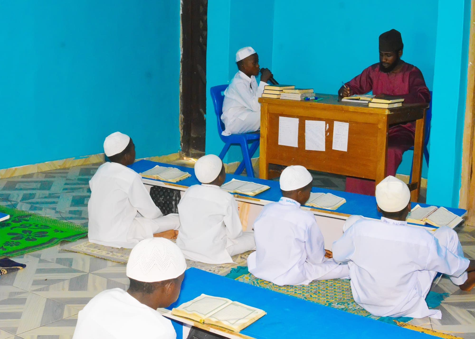Tahfiz students following the recitation with their Qur’ans open