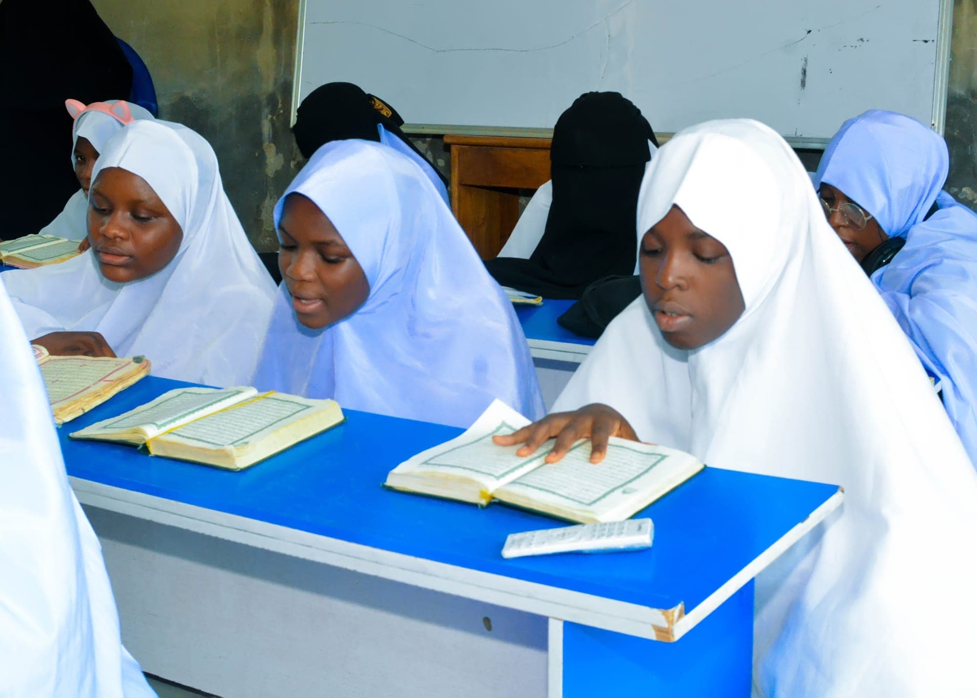 A Tahfiz girl following the Qur’an line by line as she recites